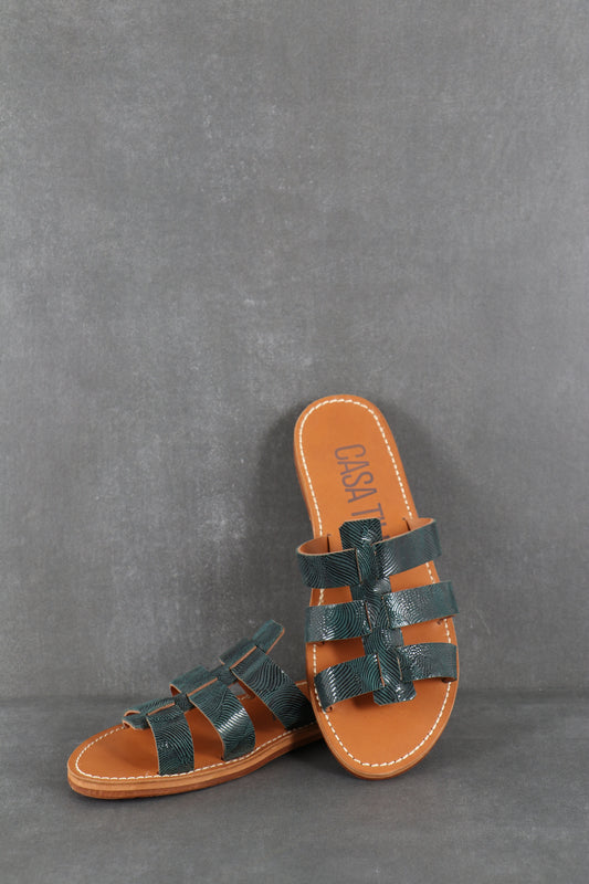 Mules plates en cuir bleu texturé pour femmes.