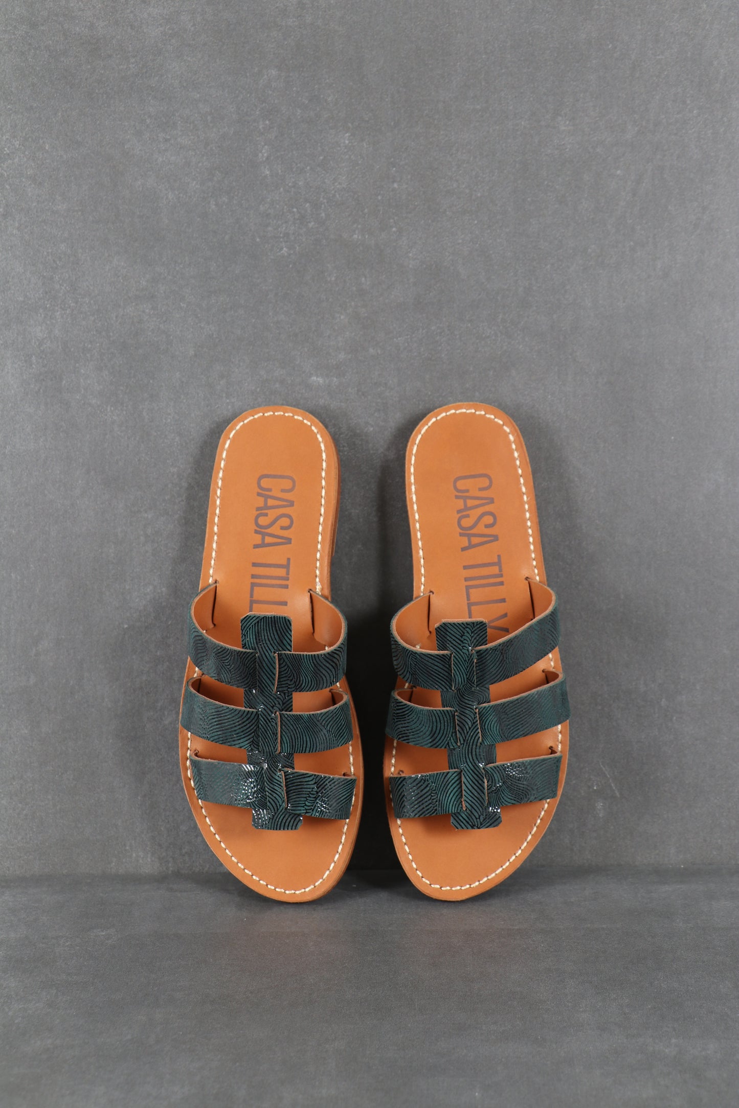 Mules plates en cuir bleu texturé pour femmes.